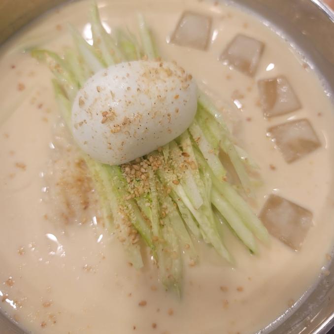 진하고 고소한 콩국수 만들기 완성 사진. 시원한 콩국수 한 그릇, 오이채와 얼음이 올려진 여름 면요리